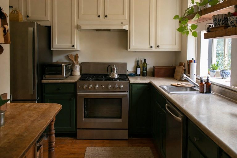 An ordinary kitchen with deep green lower cabinets and light upper cabinets in two-tone contrast